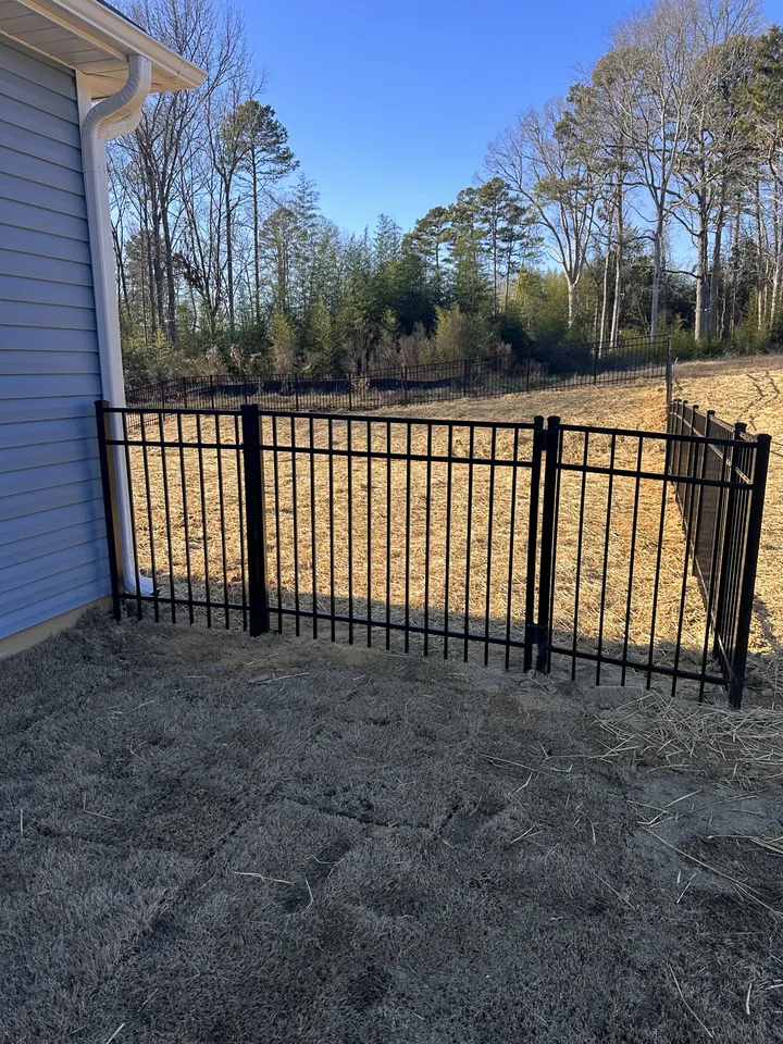 Black aluminum fence and walk gate at a new construction home.