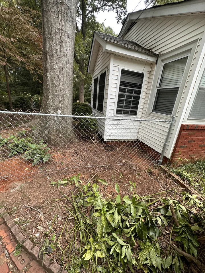 Galvanized chain link fence beside a house corner.