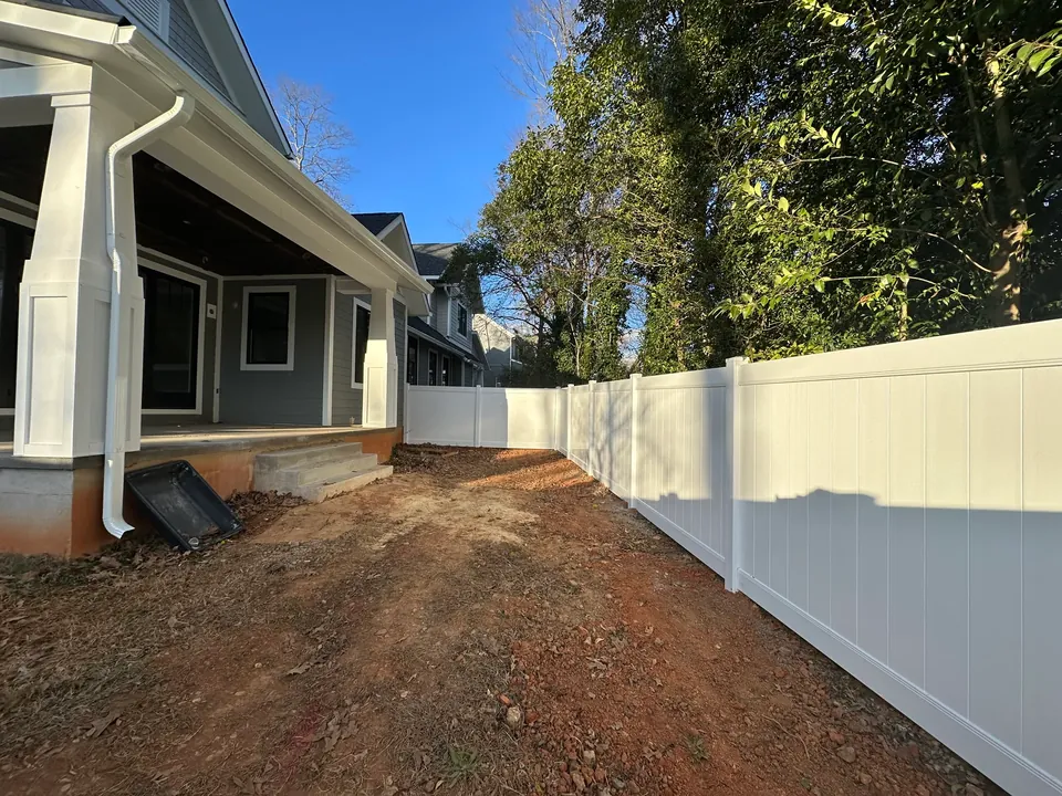 White vinyl privacy fence enclosing a new home backyard.