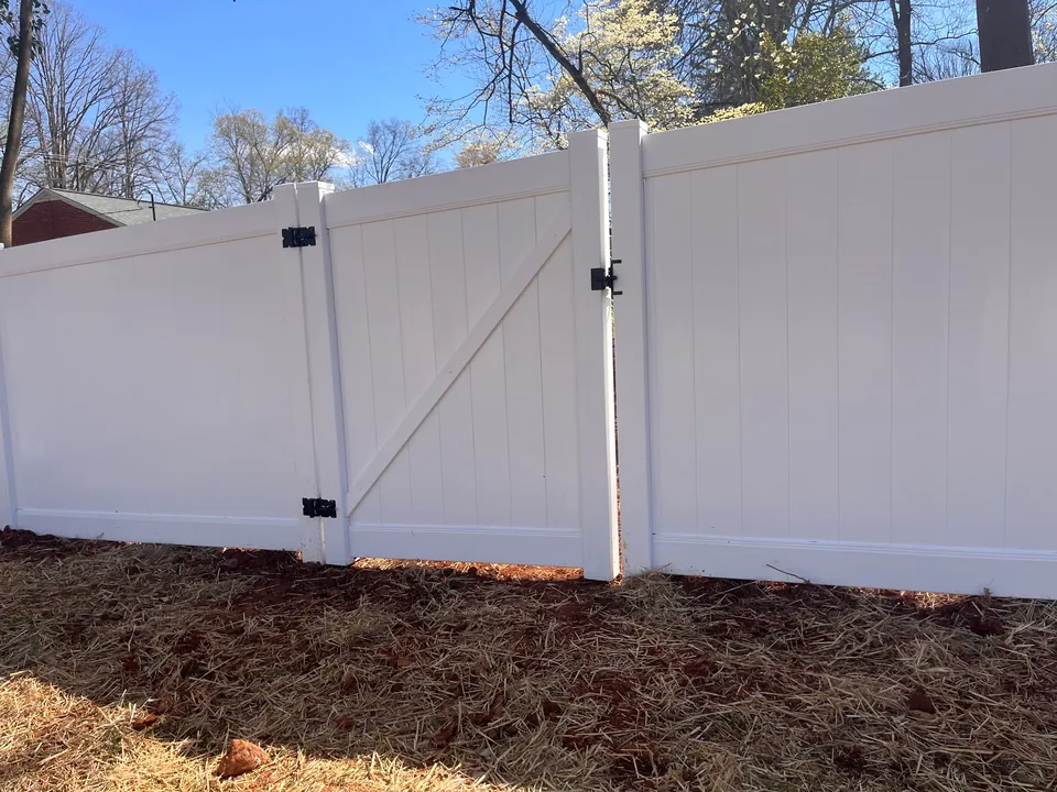 White vinyl privacy fence with a walk gate.